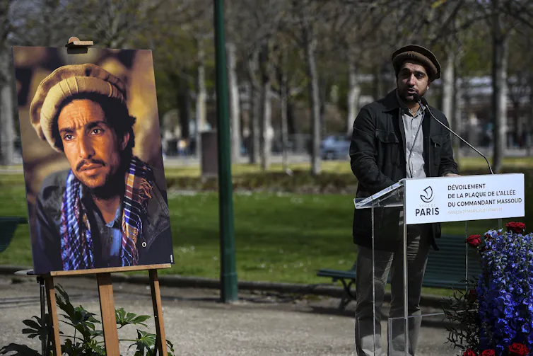 Afghan resistance leader Ahmad Massoud stands next to a portrait of his father Ahmad Shah Massoud.
