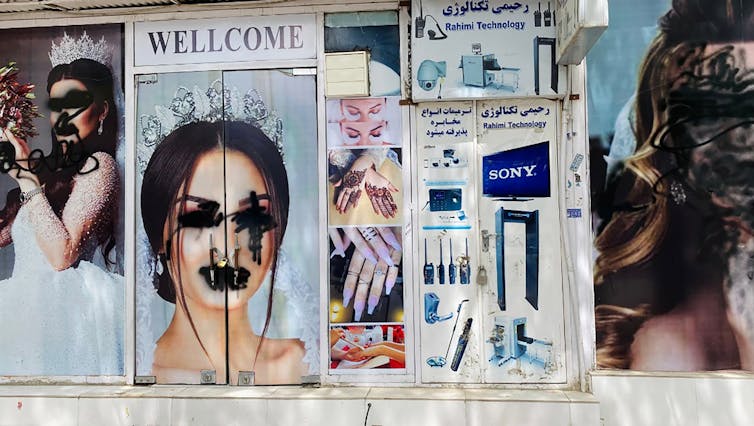 Defaced posters of women outside a beauty parlour in Kabul.