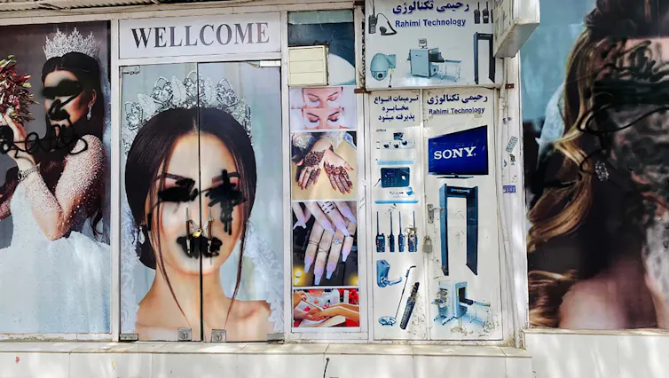 Defaced posters of women outside a beauty parlour in Kabul.