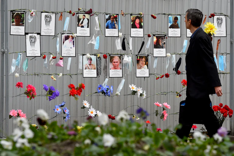 A man walks past a makeshift memorial.