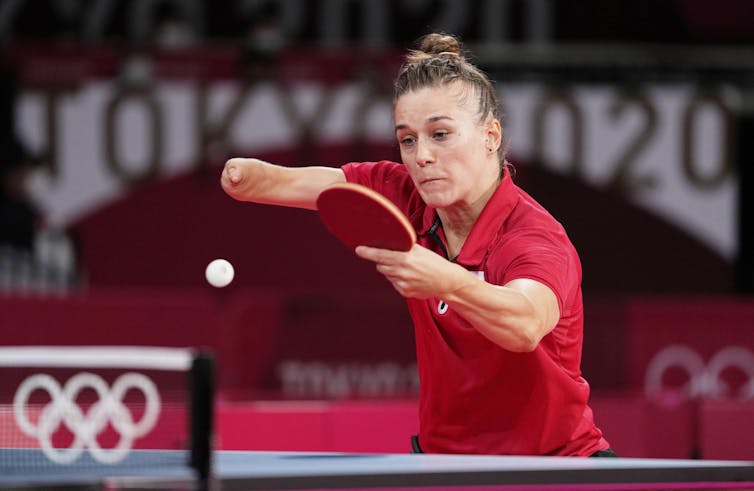 Polish Paralympian Natalia Partyka in a red shirt bats back a table tennis ball during a match