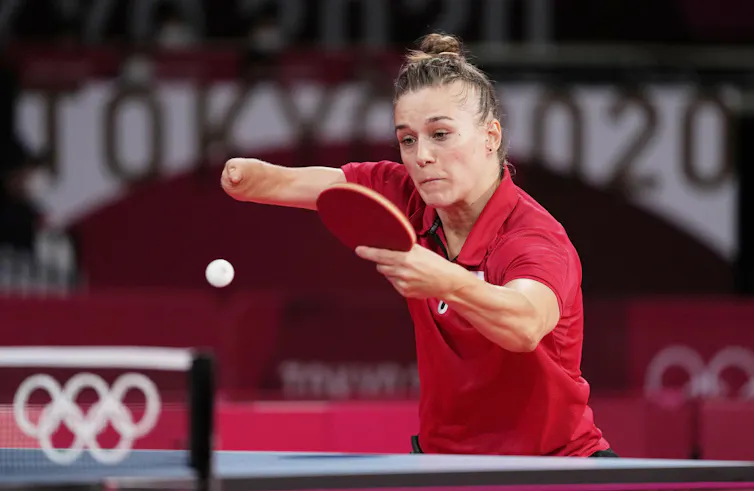 Polish Paralympian Natalia Partyka in a red shirt bats back a table tennis ball during a match