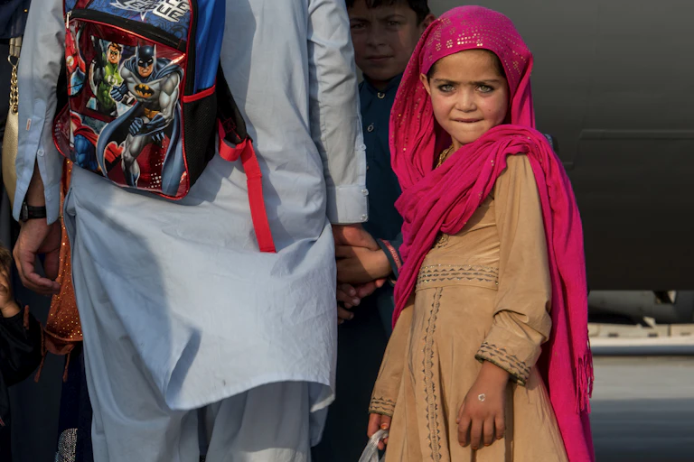 An Afghan girl waits with her family to board a C-17 Globemaster lll on Aug. 22, 2021, at Al Udeid Air Base, Qatar.