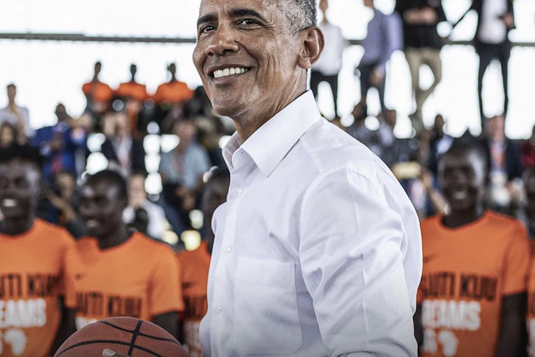 A man holding a basketball and smiling.