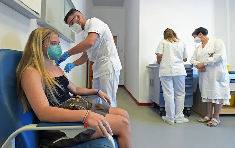 A girl in Italy being vaccinated for COVID-19