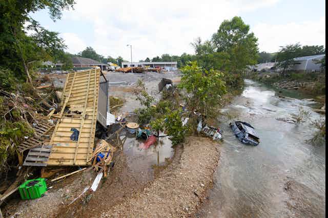 A scene after a flash flood, with a home and car partially submerged