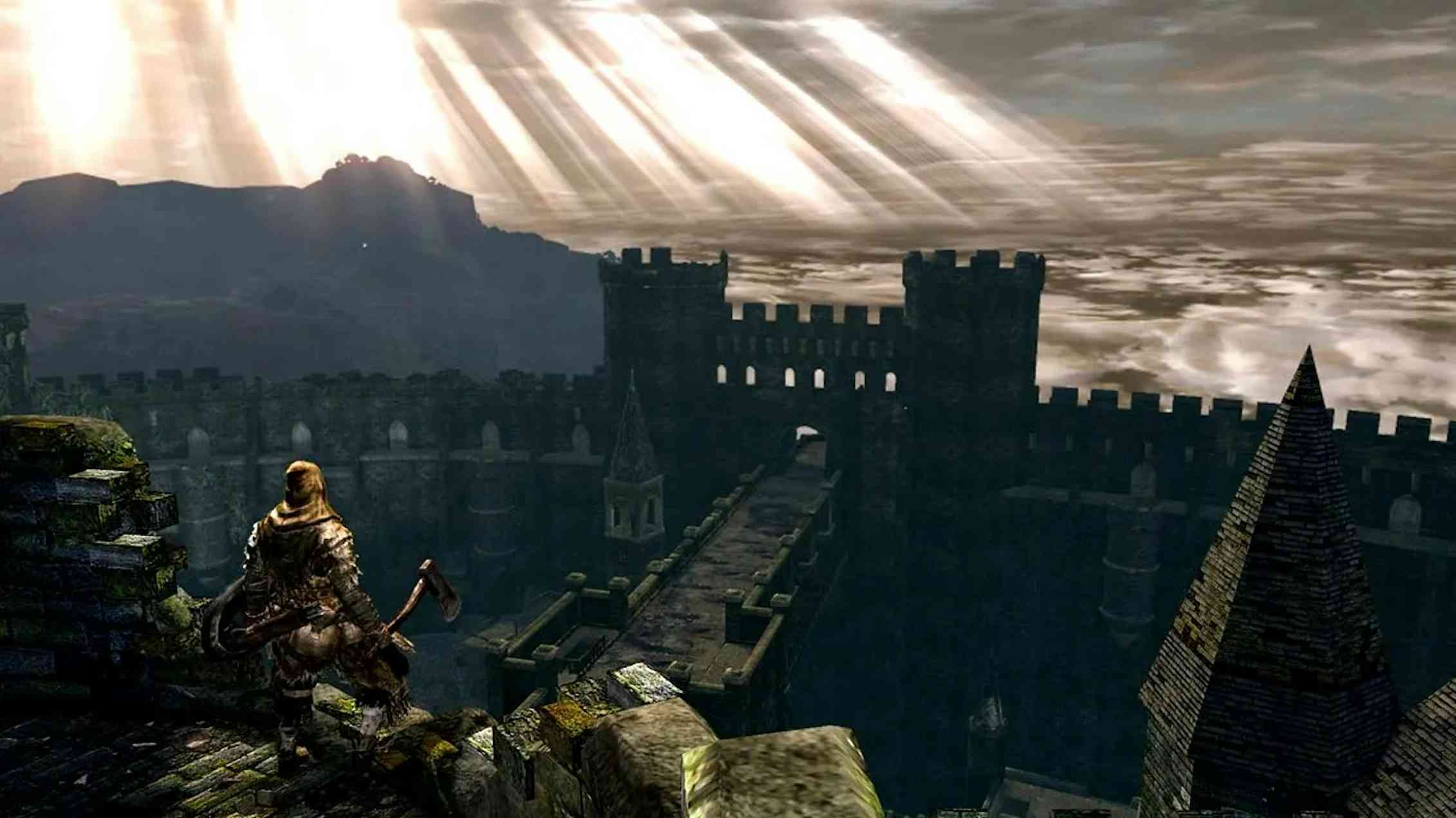 A knight in armour faces a sun-streaked sky and wall of ruins.