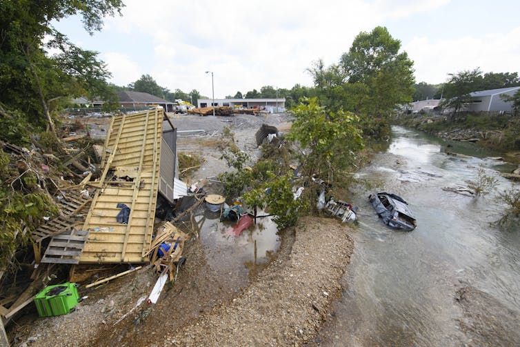 An overturned trailer and a flooded car were washed away in a creek by a flash flood during heavy rains in Tennessee.