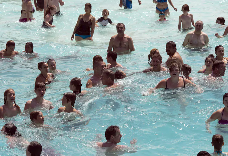 Des gens pataugent dans une piscine