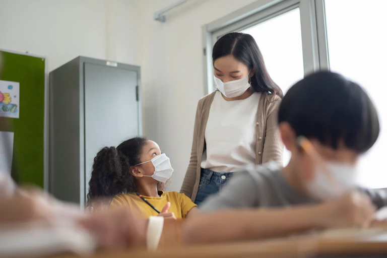 Children wearing masks in a classroom.