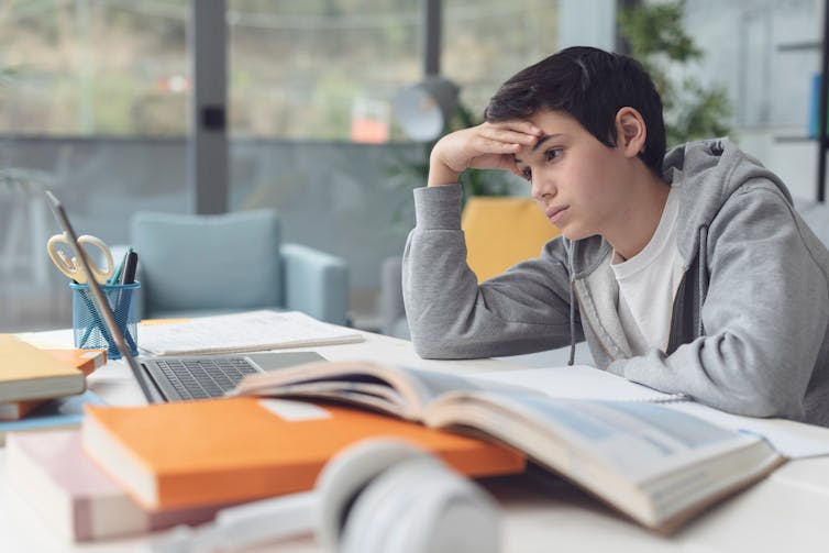 Tired students at the desk at home.