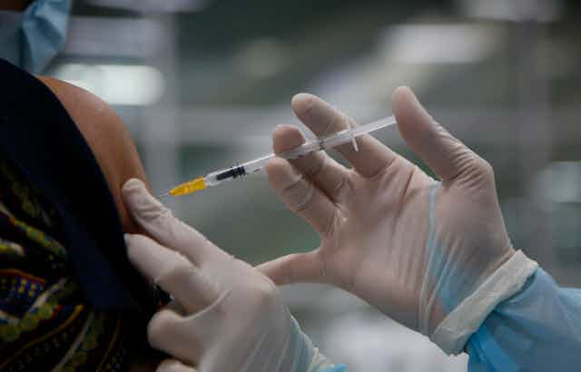A person receiving a COVID-19 vaccine
