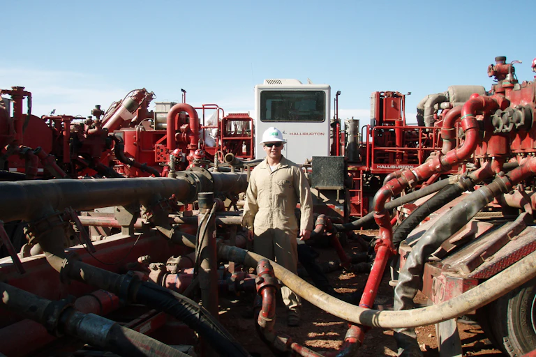 A worker surrounded by fracking equipment