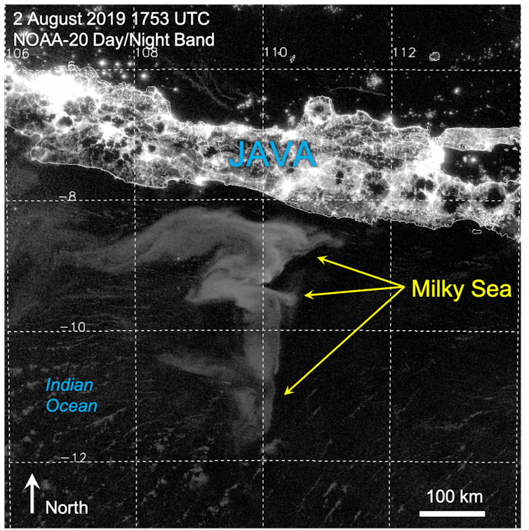 A satellite image of a massive, question mark-shaped white area off the coast of a brightly lit island.