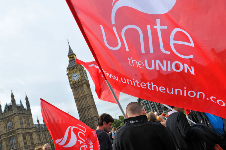 A man waves a Unite the union flag in front of Westminster