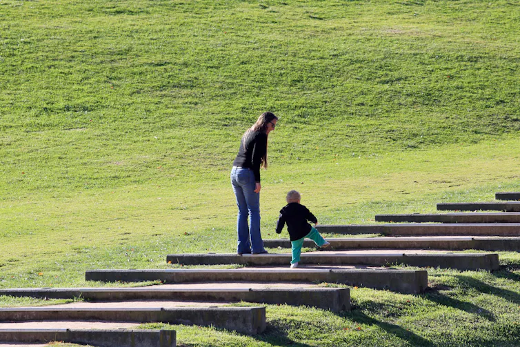 Mother and small child climbing steps.