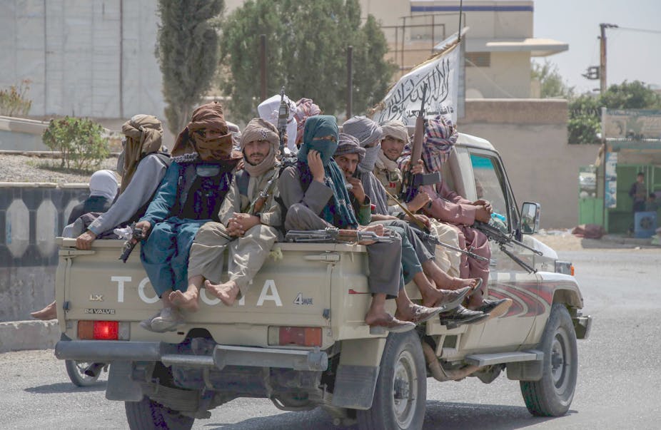 Taliban sit on back of pickup truck in Kandahar.