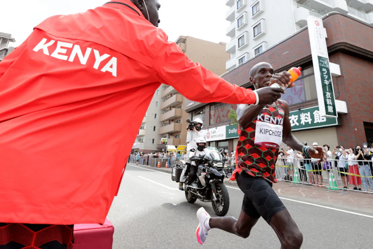 Runner receives his drink bottle