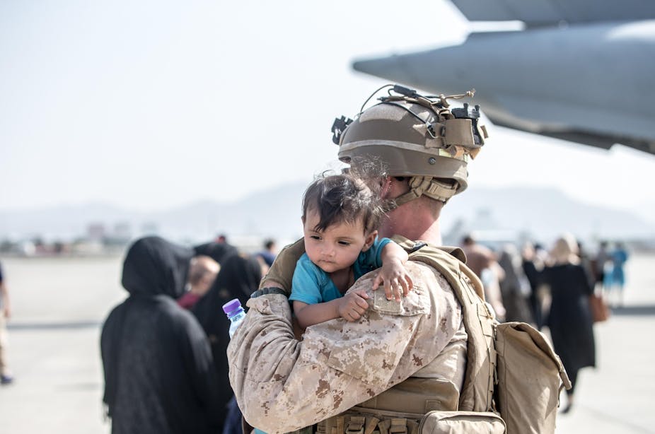 Un Marine américain tient un bébé dans ses bras à l'aéroport de Kaboul
