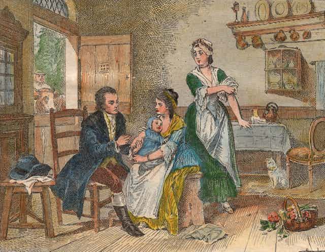 Coloured engraving of baby on mother's lap receiving a vaccine in England in the 1700s.