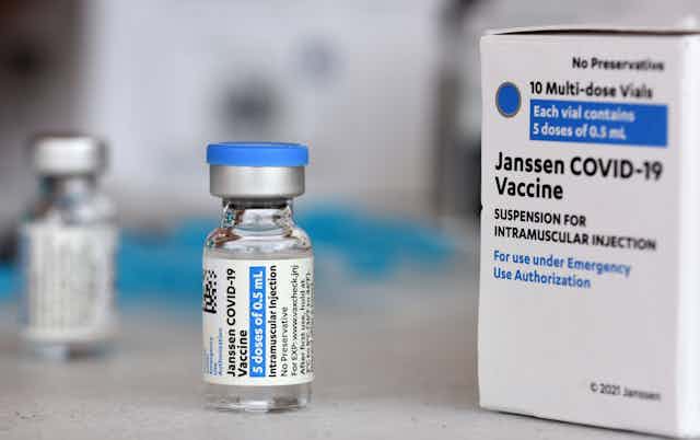 A vaccine vial next to a vaccine box.