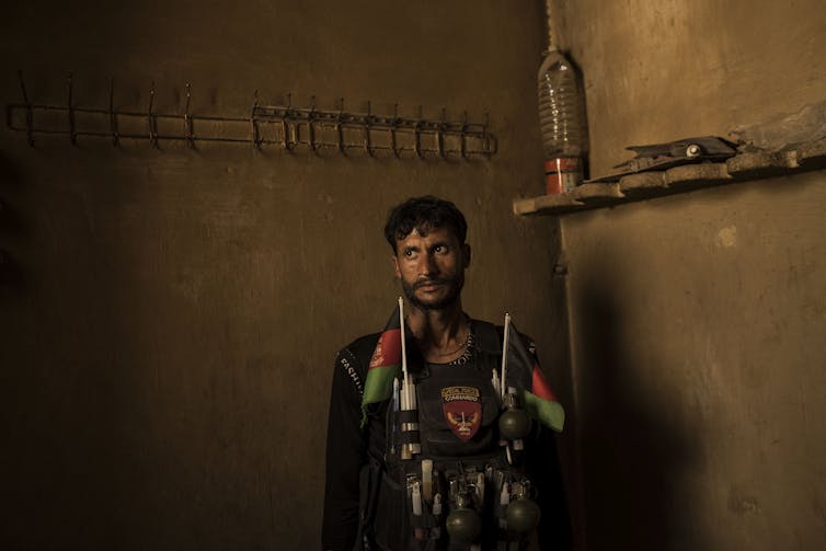 A soldier with the Afghan National Army stands in a room at an a building previously used as of a jail by ISIS-K.