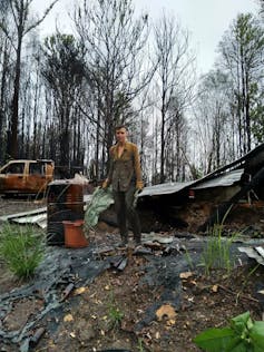 A person stands in a burnt-out home
