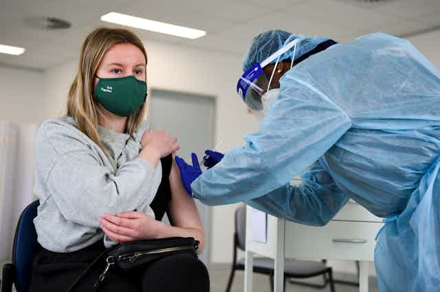 A young woman receives a vaccination.