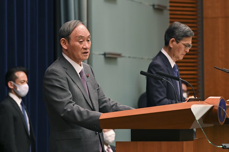 Japan's prime minister Yoshihide Suga attending a news conference with the chairman of the government's pandemic advisory panel, Shigeru Omi
