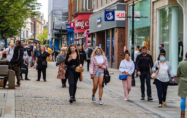 People walking down a shopping street in Manchester, UK