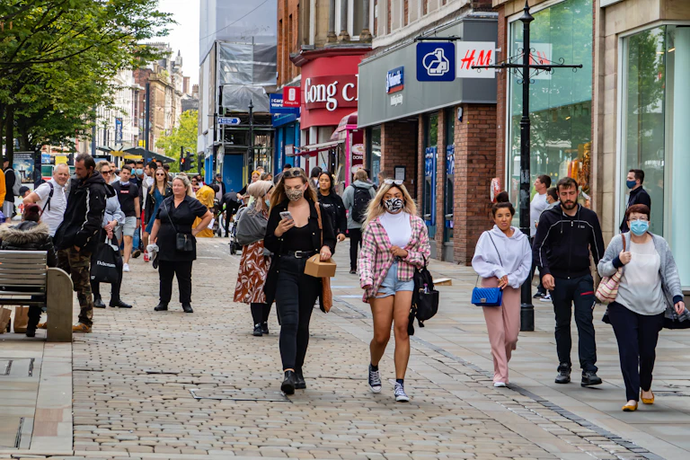 People walking down a shopping street in Manchester, UK