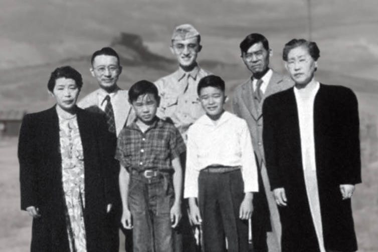 A black and white photo of a group of people of different ages