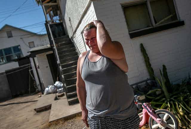 A distraught woman walks away from a home she has been evicted from