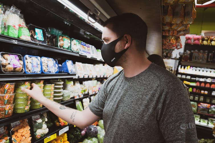 Man in a mask shops for dip.