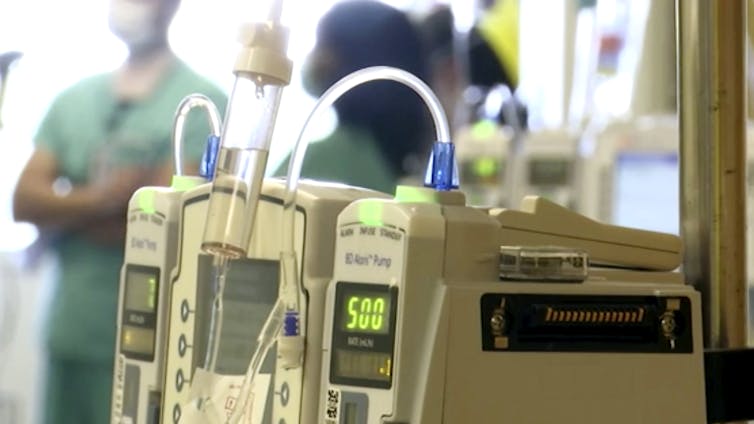 Hospital equipment sits in front of clinicians in scrubs.