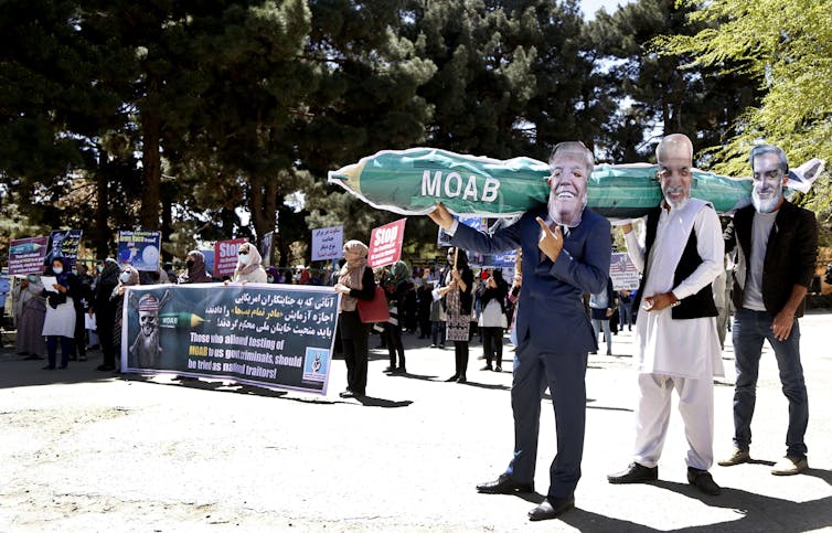 Afghan protesters wearing masks depicting Donald Trump, Afghan president Asraf Ghani and vice-president Abdullah Abdullah aftert the US dropped the largest non-nuclear bomb on Afghanistan.