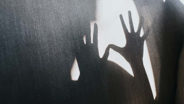 A silhouette of outstretched hands.