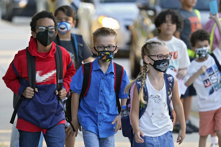 Children with backpacks walking to school.