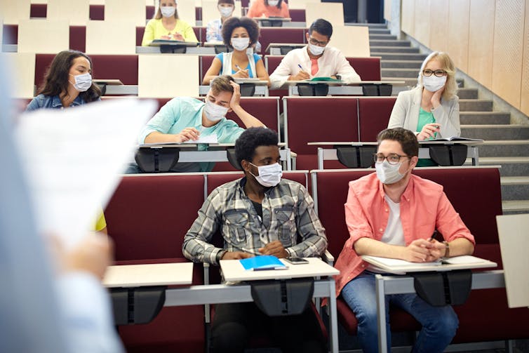 Groupe de jeunes portant un masque, dans une salle de cours