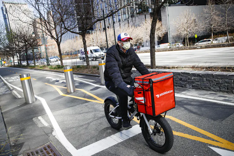 A delivery worker riding a bike.
