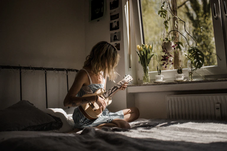 A woman plays a ukulele