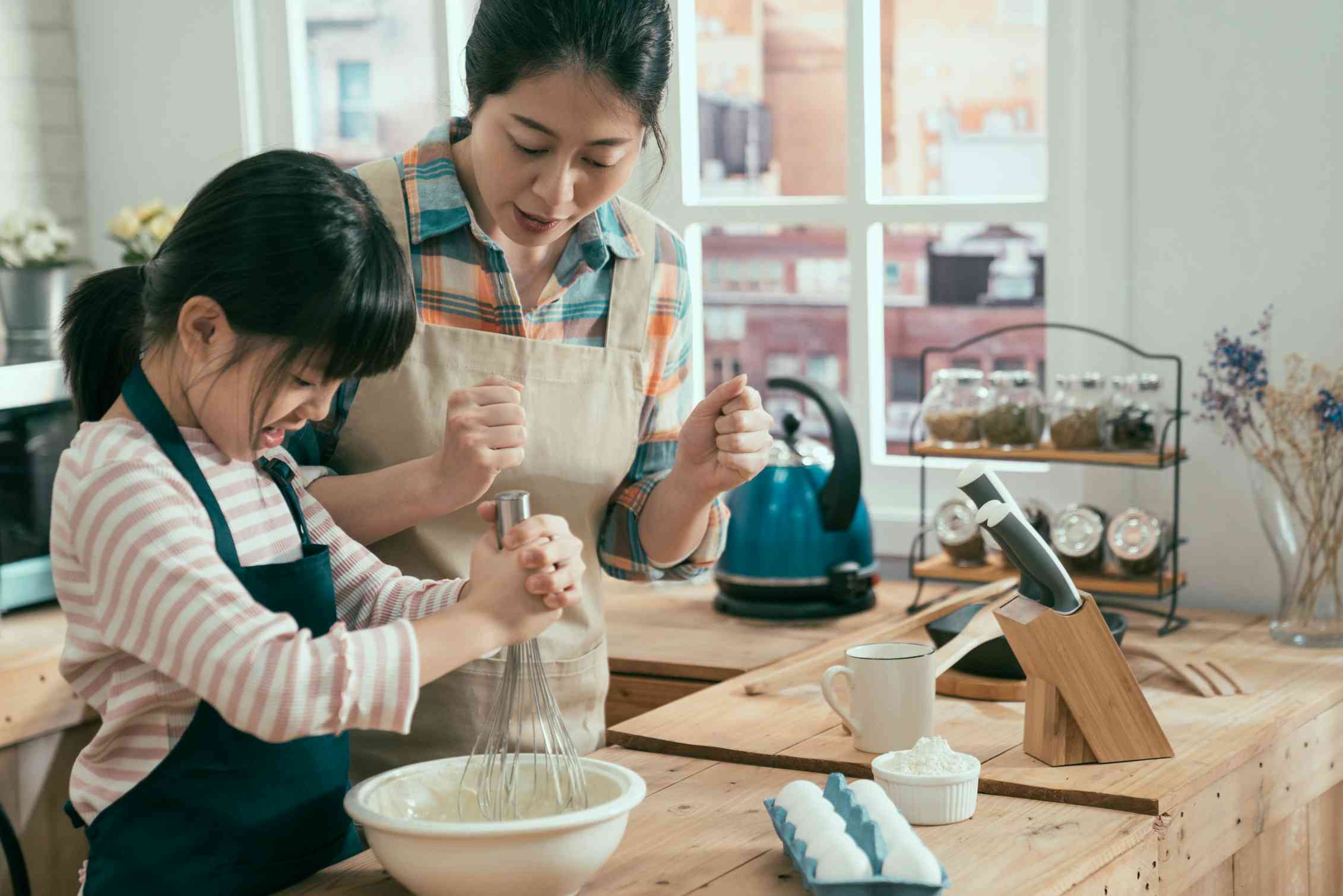 An Asian girl and mother bake.
