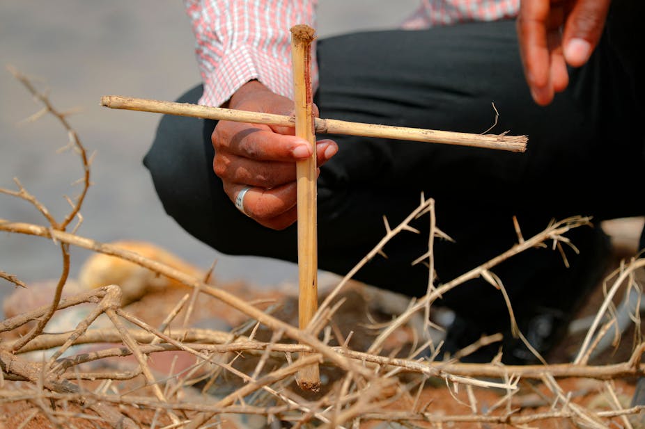 A cross made from twigs is planted on the ground