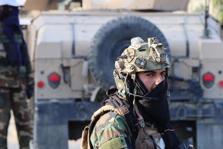 A Taliban fighter dressed in army fatigues with his face half covered.