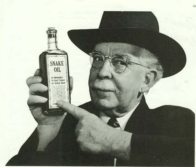 Man holding up a bottle of snake oil