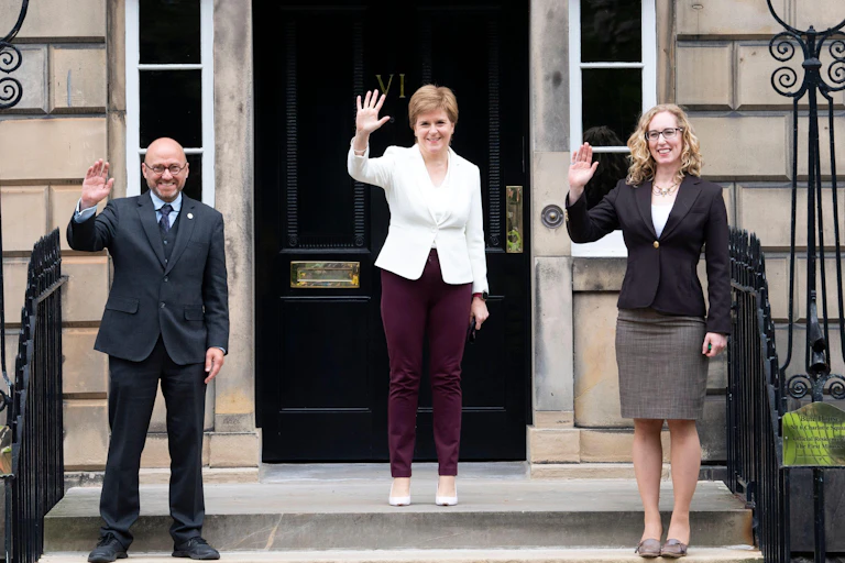 Scottish Green co-leaders Patrick Harvie, Nicola Sturgeon and Lorna Slater waving from the steps of Bute House.