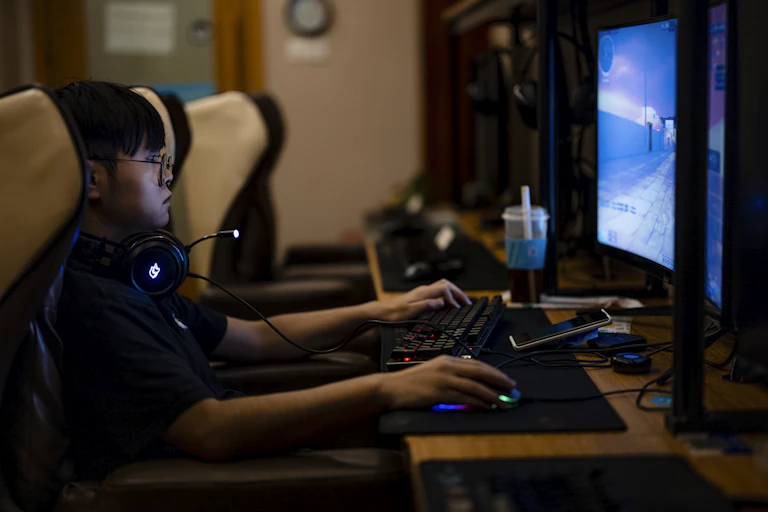 A man in China faces a screen while playing a video game.