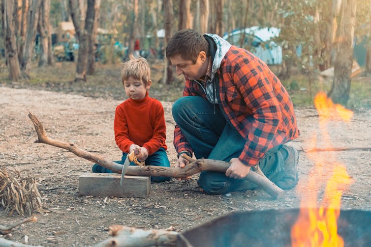 Father and son cutting a log in the forest at Kuitpo, South Australia.