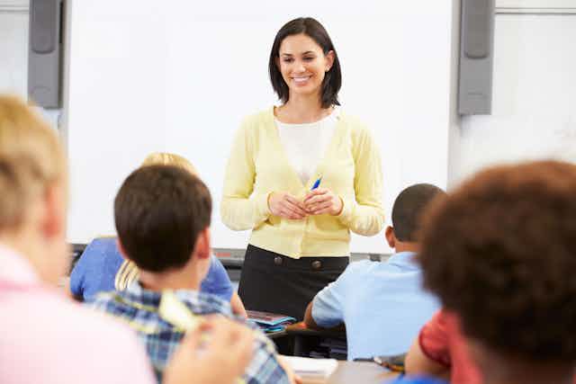 Young teacher standing in front of the class.
