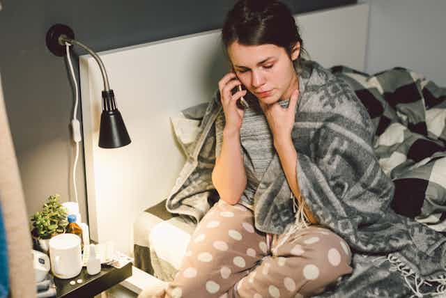 Sick woman at home on phone